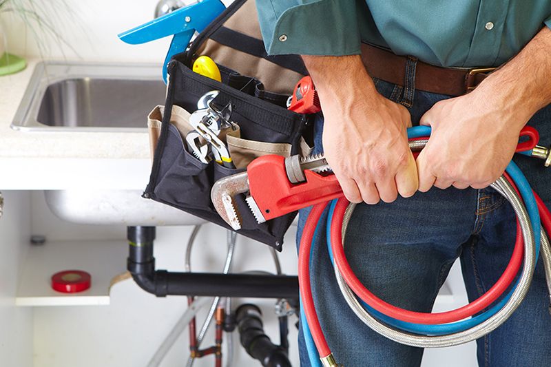 Image of plumber holding tools.